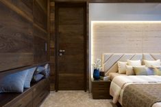 a large bed sitting next to a wooden wall