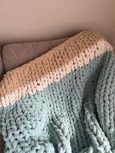 a crocheted blanket sitting on top of a couch