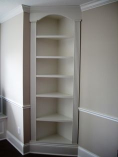 an empty bookcase in the corner of a room