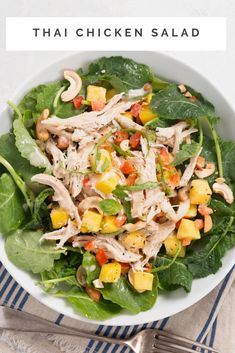 a white bowl filled with chicken salad on top of a blue and white table cloth