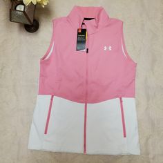 Pink And White Fitted, Full Zip, Cold Gear Sleeveless Jacket Vest. Zippered Pockets. White Sleeveless Top With Pockets, White Sleeveless Outdoor Outerwear, Sporty Spring Outerwear Vest, White Fall Vest Outerwear, White Vest With Pockets For Spring, White Outdoor Vest For Fall, White Vest Outerwear For Spring, Casual White Vest Outerwear, White Spring Vest With Pockets