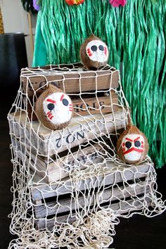 two monkey heads are sitting on top of a crate with string wrapped around it and some fake grass in the background