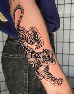 a person with a tiger tattoo on their arm