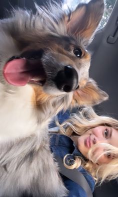 a woman sitting in the back seat of a car with a dog on her lap