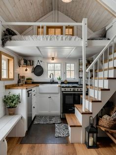 a kitchen with stairs leading up to the top floor and an open loft above it