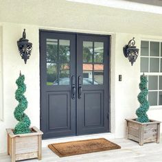 two wooden planters sitting in front of a double door with the words best iron door designs