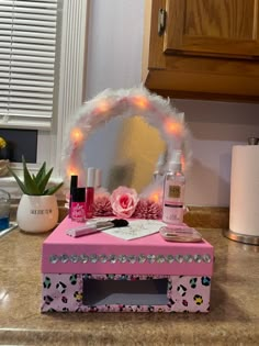 a pink vanity with lights on it and a mirror in the corner next to it