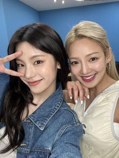 two young women posing for the camera with their fingers in the shape of a peace sign