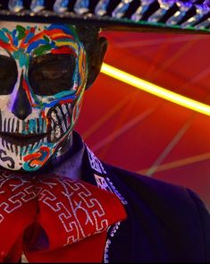 a man with painted face and tie wearing a sombrero