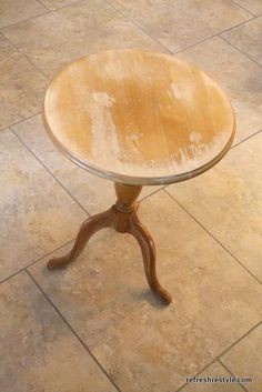 a small wooden table on a tile floor