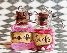 two small bottles filled with candy sitting on top of a checkered floor