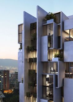 a tall building with lots of windows and plants growing on the side of it's sides