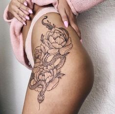 a woman's thigh with flowers on it and a snake crawling around the side