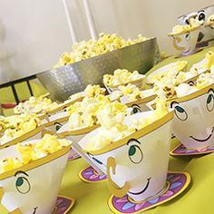 there are many cups with faces on them and popcorn in the shape of mugs