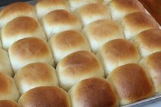 a pan filled with bread rolls sitting on top of a wooden table