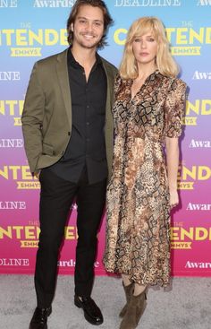 a man and woman standing next to each other on a red carpet at an event