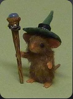 a toy mouse with a green hat holding a stick