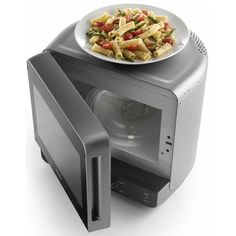 a plate of food sitting on top of an open microwave oven with it's door open