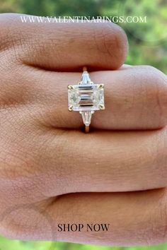 a woman's hand holding an engagement ring with a large diamond in the center