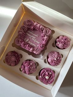 a box filled with cupcakes covered in pink frosting and decorated with flowers