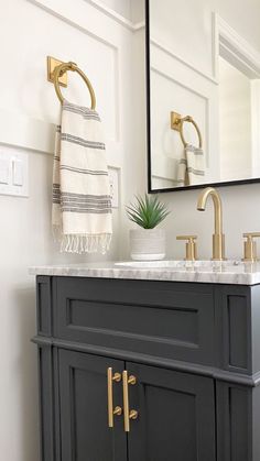 a bathroom vanity with gold faucet and mirror