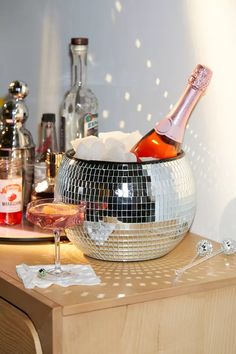 a disco ball sitting on top of a table next to a wine glass and bottle