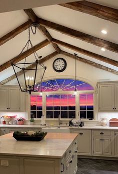 a kitchen with a large window and a clock on the wall above the counter top