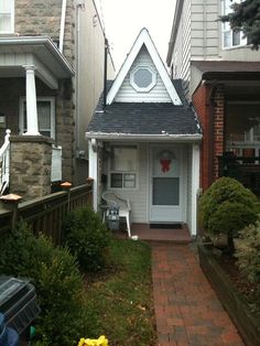 a small house with a white door and black roof