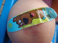 a close up of a child's knee with a sticker on it that has a dog on it