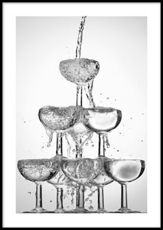 a water fountain filled with lots of different kinds of wine goblets in black and white