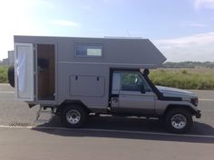 a truck is parked on the side of the road with a small house in it