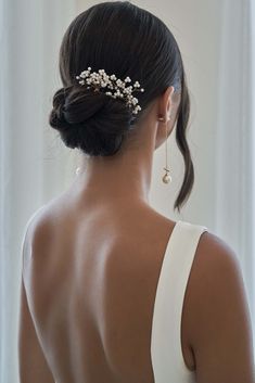 the back of a woman's head wearing a hair comb with pearls on it