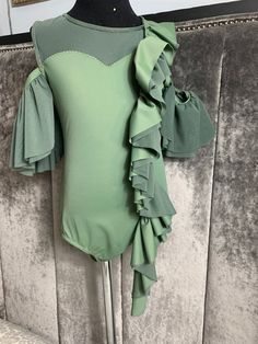 a green bodysuit with ruffled sleeves on a mannequin