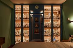 a bed sitting in a bedroom next to a book shelf filled with figurines