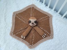 a crocheted stuffed animal sitting on top of a white blanket