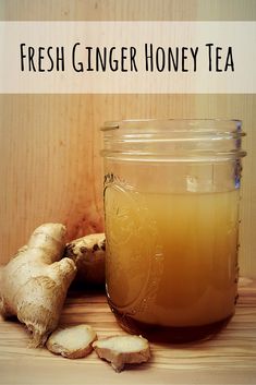 fresh ginger honey tea in a glass jar next to sliced ginger