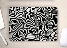 a computer mouse pad with black and white swirls on it next to a keyboard