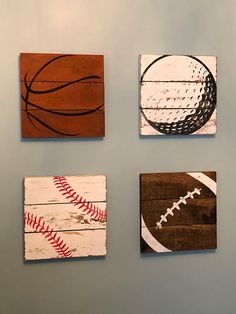 four different pieces of wood with baseball, basketball and soccer ball on them hanging on the wall