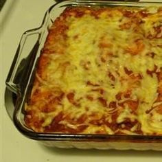 a casserole dish with meat and cheese in it sitting on a stove top