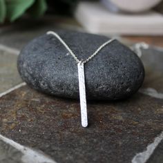 This is a simple sterling silver hammered bar necklace that makes a perfect gift for a teacher, hostess, or loved one. And, it looks great by itself or layered with other chains. Here are the details: I saw the 1 1/4" bar from thick rectangular sterling silver wire and hammer for texture. The finished length is available in 16 or 18 inches. Chain style may vary, depending on what I have on hand...although it will always be sterling silver. Silver Sterling Silver Bar Necklace With Rectangular Pendant, Silver Bar Necklace Perfect As A Gift, Minimalist Sterling Silver Bar Necklace With Rectangular Pendant, Minimalist Silver Engraved Bar Necklace, Minimalist Engraved Silver Bar Necklace, Silver Dainty Bar Necklace For Everyday, Dainty Sterling Silver Bar Necklace For Everyday, Minimalist Hammered Jewelry With Rectangular Pendant, Minimalist Hammered Rectangular Pendant Jewelry