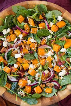 a salad with spinach, carrots, feta cheese and cranberries