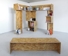 a wooden shelf with books on it in an empty room