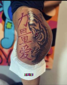 a man with a tiger tattoo on his leg and the word tigers written in chinese