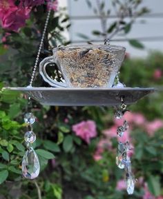 a tea cup hanging from a bird feeder