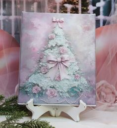 a christmas tree with pink roses and bows on it's side is displayed in front of a backdrop