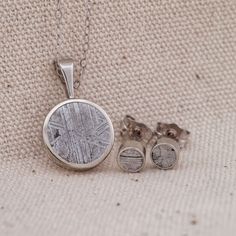 "This 14k Gold Pendant/Earring set is elegant yet minimalist.  Sure enough to spark conversation and perfect as a gift for that special loved one.  Made from authentic Etched Muonionalusta Meteorite.  Hand crafted and acid etched to show the unique patterns/details. These pieces are shown in White Gold but can be made in the metal of your choice at checkout. They are made from natural materials so each one will be different/unique but similar to what is pictured. Pendant Dimensions: Metal: 14k Gold Finish: Polished - 11mm Diameter - 2.5mm Thickness - 16\" 14k Gold Chain Earring Dimensions: Metal: 14k Gold Finish: Polished - 4mm Diameter - 2.5mm Thickness" Pendant Earring Set, Gold Chain Earrings, Meteorite Pendant, Pendant Earring, Jade Stone, Stud Earrings Set, Chain Earrings, Stud Earring, Pendant Earrings