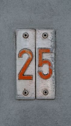 the number twenty five is painted orange and white