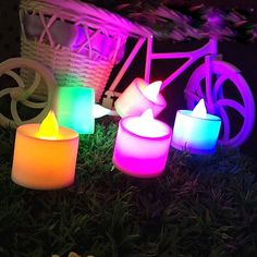 several lit candles sitting in the grass next to a bicycle