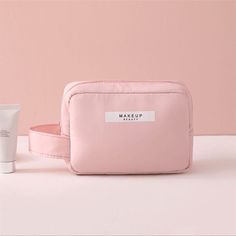 the makeup bag is pink and has two items in it, including an empty container