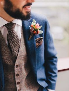 a man wearing a suit and tie with a boutonniere on his lapel